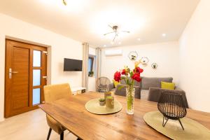 a living room with a wooden table with flowers on it at Apartment Olive in Kaštela