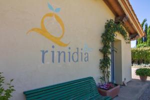 a sign on the side of a building with a green bench at Rinidia Bio in Sovicille