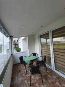 d'un balcon avec une table, des chaises et des fenêtres. dans l'établissement Apartman Lili, à Ohrid