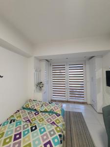 - une chambre avec un lit et une fenêtre avec des stores dans l'établissement Apartman Lili, à Ohrid