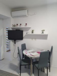 a dining room with a table and chairs and a tv at Apartman Lili in Ohrid