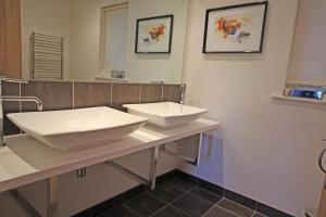 a bathroom with two sinks and a mirror at Cottage surrounded by woodland and vineyards. in Kent