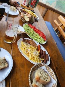 a wooden table with plates of food on it at Grand Tara Rafting Resort in Foča