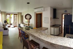 馬塔迪聖若昂的住宿－PRAIA DO FORTE ! Vilage de 80 m2 a 600 metros da vila，一个带柜台的厨房和一些椅子