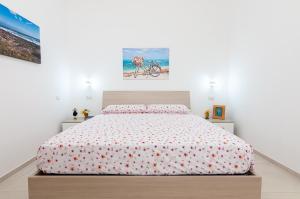 a bedroom with a bed with a white wall at Villa Marisa Holiday Home in Punta Prosciutto