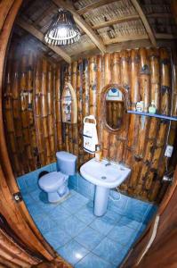 a wooden bathroom with a toilet and a sink at AGUACLARA un castillo de arena seguro y privado! in Ballenita