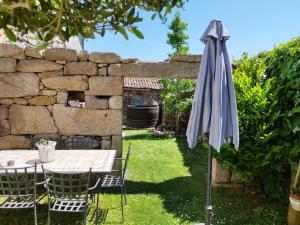 - une table et des chaises avec un parasol dans le jardin dans l'établissement Casa Elvira, à San Amaro