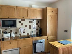 a kitchen with wooden cabinets and a stove top oven at Apartment 8 The Landings in Filey
