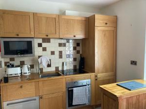 Una cocina con gabinetes de madera y un horno de estufa. en Apartment 8 The Landings, en Filey