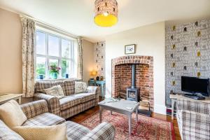 a living room with couches and a brick fireplace at 2 Siluria Cottage in New Radnor