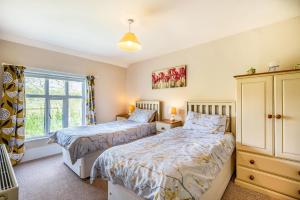 a bedroom with two beds and a window at 2 Siluria Cottage in New Radnor
