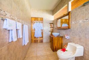 y baño con aseo, lavabo y espejo. en Drake Bay Getaway Resort en Drake