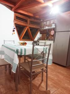 uma mesa e cadeiras numa cozinha com um frigorífico em Hermoso Domo ECOconstruido em San Pedro de Atacama