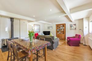 a living room with a table and a couch at The Old School Cottage in Woodsford