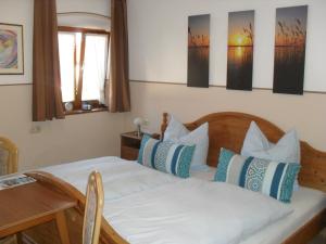 Schlafzimmer mit einem Bett mit blauen und weißen Kissen in der Unterkunft Dowis-Hof in Seebruck