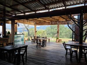 a dining room with tables and chairs and a large window at La Meca Glamping in Guasca