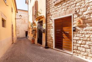 an alley with two garage doors and a brick building at Lo Speziale - Paccasassi in Sirolo