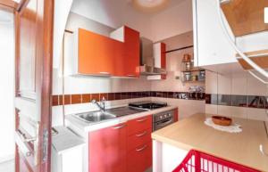 a kitchen with red cabinets and a sink at Casa di Maria a Bosco in San Giovanni a Piro