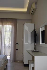 a bedroom with a bed and a tv and a mirror at olivegrove in Sidari
