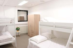 a room with two bunk beds and a mirror at Budget Rooms Copenhagen in Ishøj