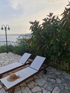 un sombrero y dos mesas de picnic en un patio en Gran Domenica Villa Corfu, Private Pool, Sea View, Garden en Nisaki