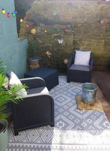 an outdoor patio with two chairs and a table at Caudle Cottage, Ruardean in Lydbrook