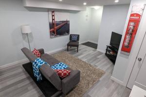 a living room with a couch and a television at SERENE & MODERN 1BED SUITE + CLOSE TO AIRPORT in Regina