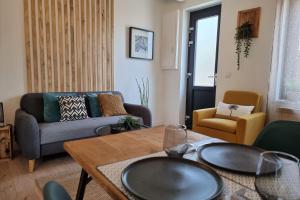 ein Wohnzimmer mit einem Sofa und einem Tisch in der Unterkunft Rive Sud - Charmante Maisonette 2 P - Stadtzentrum in Honfleur