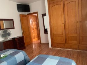 a bedroom with two beds and wooden cabinets at Casa Gran Sol, La Gomera in Playa de Santiago