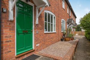 a green door on the side of a brick building at 4 Aldelyme Court in Audlem