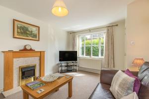 a living room with a couch and a fireplace at 4 Aldelyme Court in Audlem