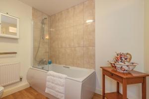 a bathroom with a white tub and a shower at 4 Aldelyme Court in Audlem +17 photos