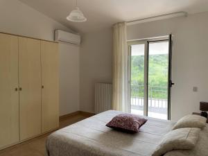a bedroom with a bed and a large window at Casa di Maria a Bosco in San Giovanni a Piro