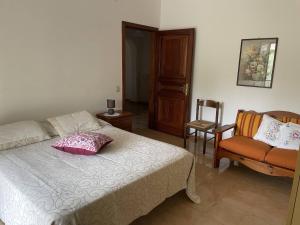 a bedroom with a bed and a chair at Casa di Maria a Bosco in San Giovanni a Piro +11 photos