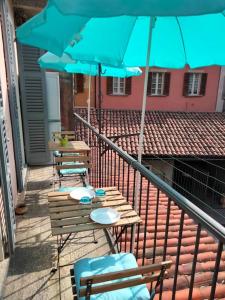 une rangée de tables et de chaises avec des parasols bleus dans l'établissement Appartamento AZZURRO, à Cannobio