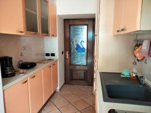 - une cuisine avec une porte, une fenêtre et un évier dans l'établissement Appartamento AZZURRO, à Cannobio