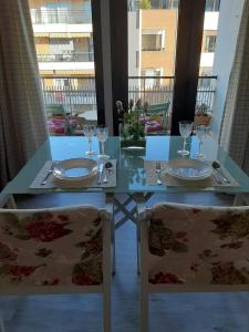una mesa con 2 sillas con platos y copas de vino en Imagen Metrosol, en Sevilla