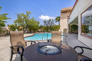 a patio with a table and chairs and a swimming pool at Best Western Plus Thousand Oaks Inn in Thousand Oaks