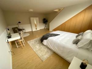 a bedroom with a large white bed and a desk at Villa Família in Ponta Delgada