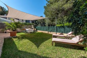 a yard with a bench in the grass at Villa Tamarells - Alcúdia in Alcudia