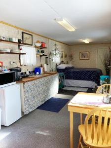 a kitchen with a table and a room with a bed at Jade City Bungalow in Jade City