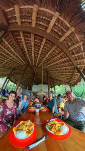 a group of people sitting at a table with plates of food at Hosteria Cumilinche in Same +170 photos