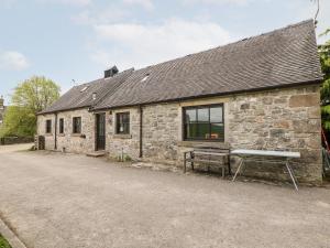 een stenen gebouw met een bank ervoor bij Croft House in Ashbourne