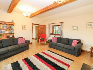 een woonkamer met 2 banken en een tapijt bij Croft House in Ashbourne