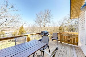 una terraza de madera con mesa de picnic y sillas. en Moon Lodge, en Reeds Spring