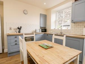 een keuken met een houten tafel en een tafel en stoelen bij Lamb Cottage in Windermere