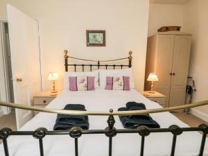 een slaapkamer met een groot bed met 2 lampen bij Lamb Cottage in Windermere