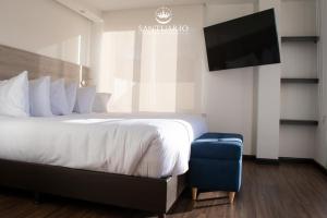 a hotel room with a bed and a flat screen tv at HOTEL SANTUARIO in Tunja