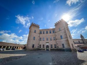 a large brick building with the sun in the sky at La Torretta, una casa inaspettata in Mesola