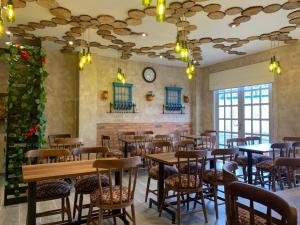 a restaurant with tables and chairs and a clock on the wall at HOTEL SANTUARIO in Tunja